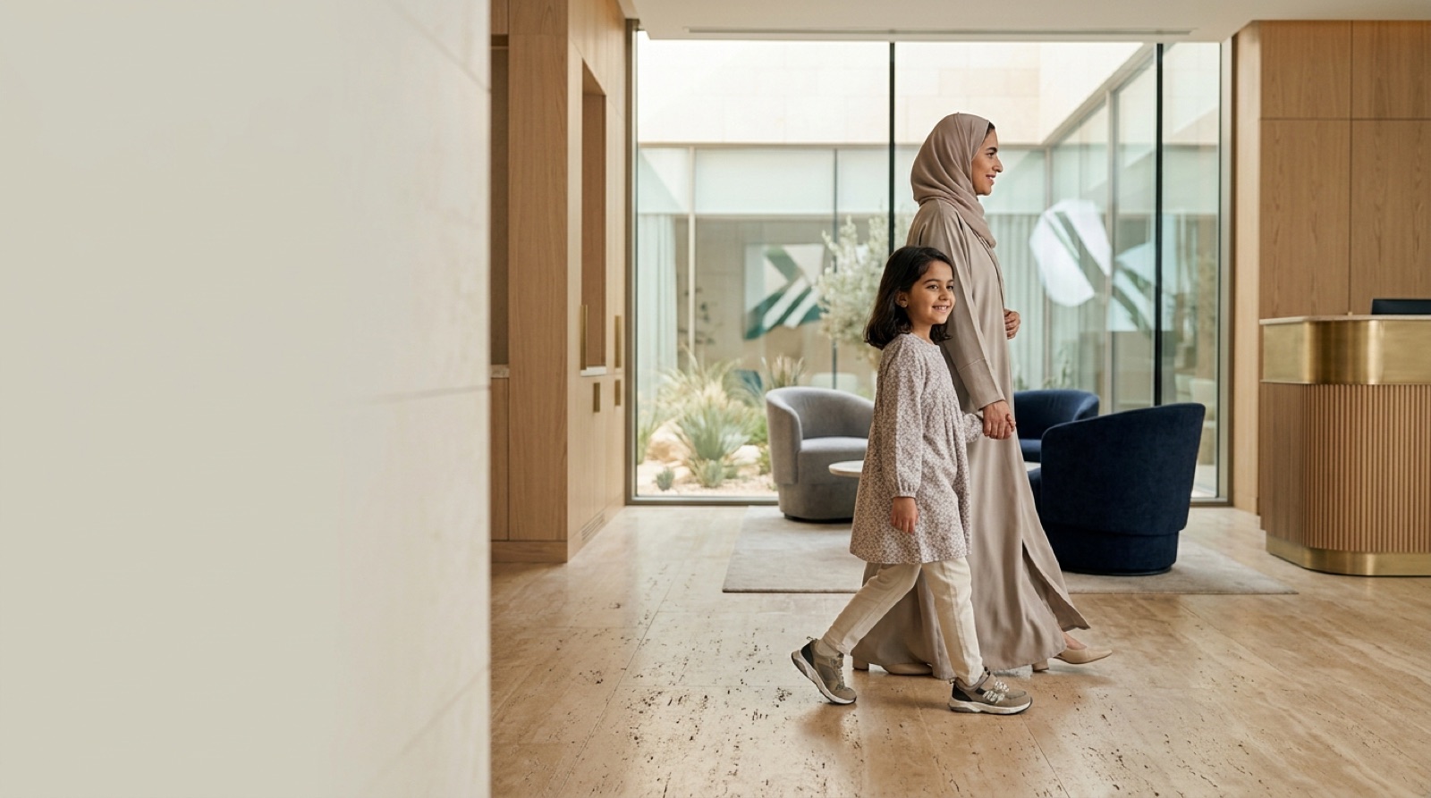 Cheerful young child walking while holding a parent's hand in a sunlit family clinic